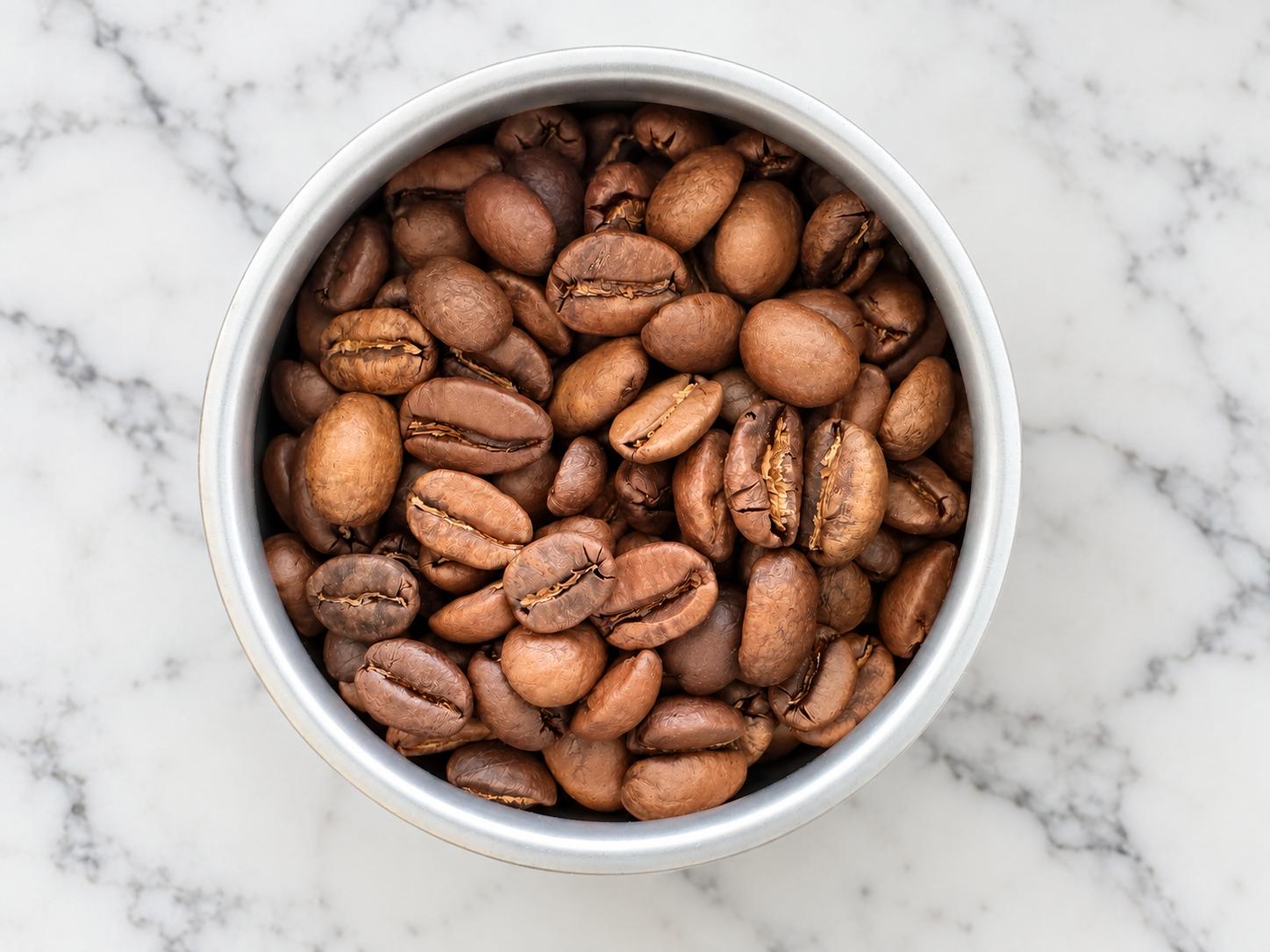 Roasted coffee beans in a beverage can from above.